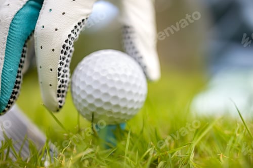Preview: Hand in glove placing golf ball on tee