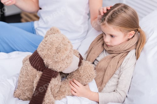 Preview: cropped image of mother taking care of sick daughter in bedroom