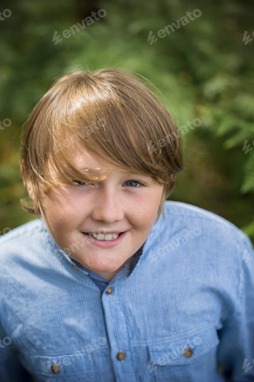 Preview: A boy in a denim button down shirt looking up at the camera.