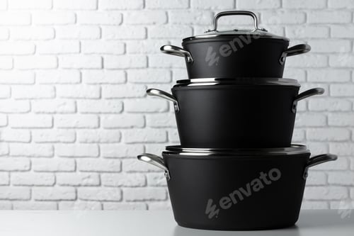 Preview: Black kitchenware on table against white brick wall