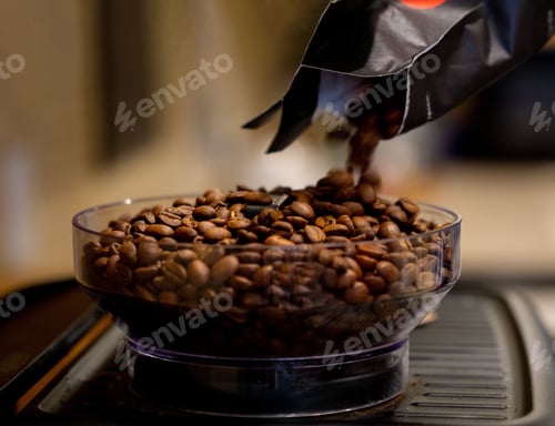 Preview: Motion blur on coffee beans bent poured into the hopper on a home espresso machine