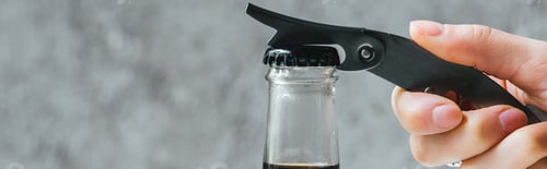 Preview: Cropped View of Woman Opening Cold Brew Coffee in Bottle With Opener, Panoramic Shot