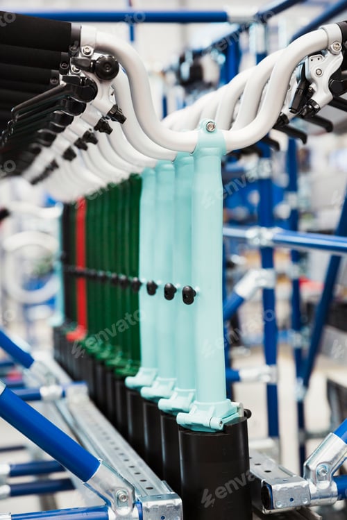 Preview: Close up of bicycle handlebars hanging up in a bicycle factory.