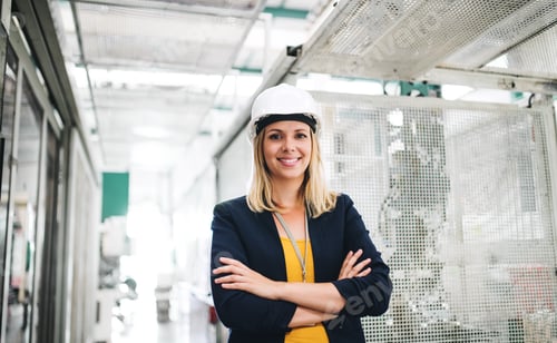 Preview: A portrait of an industrial woman engineer standing in a factory.