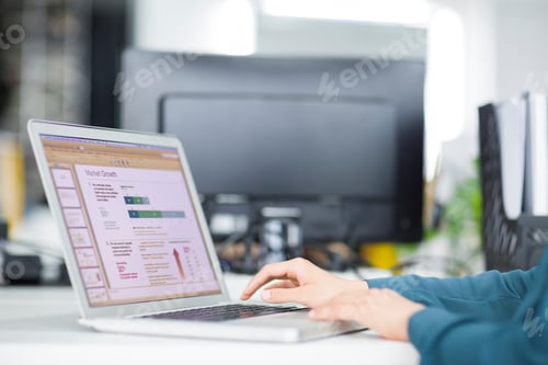 Preview: Young businesswoman using laptop in office
