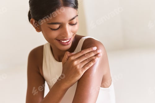 Preview: Woman Smiling While Applying Moisturizer for Healthy Glowing Skin Care Routine