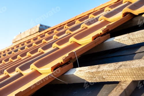 Preview: Overlapping rows of yellow ceramic roofing tiles mounted on wooden boards