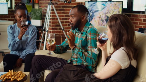 Preview: Guests laughing and discussing at apartment gathering after gifting host presents