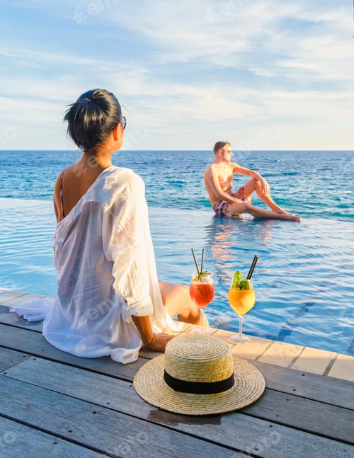 Preview: Curacao, couple man and woman mid age relaxing by the swimming pool during vacation in the Caribbean