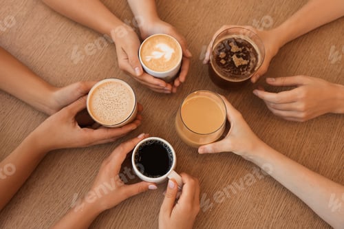 Preview: Friends drinking coffee at wooden table in cafe, top view