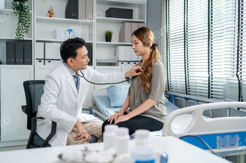 Preview: Asian cardiologist doctor listen to heartbeat patient woman in hospital.