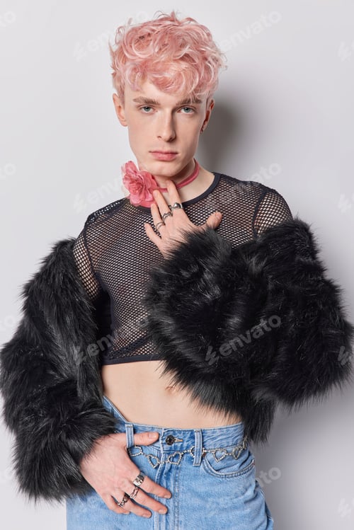 Preview: Vertical shot of serious pink haired non-binary has feminine appearance dressed in fashionable