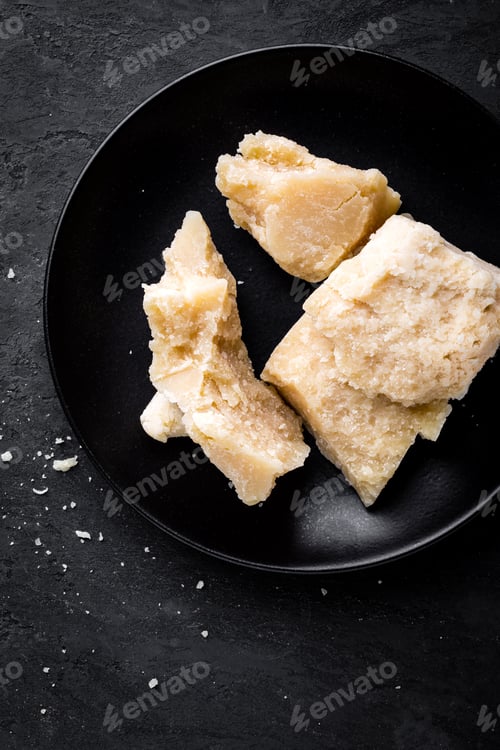 Parmesan Cheese Pieces on a Black Plate