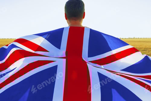 Preview: Man with a flag of Great Britain standing in field