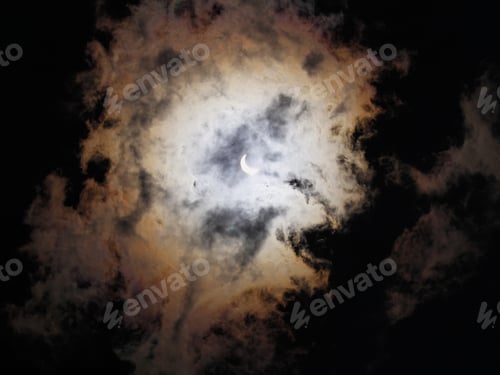 Preview: Solar Eclipse - Photograph Of A Partially Eclipsed Sun In The Center Of Some Clouds. Image