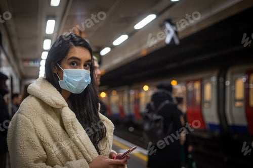 Preview: Girl waits for the subway in the London Underground, she wears a mask to use public transport