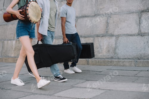 Preview: Cropped view of young people in band walking and carrying musical instruments