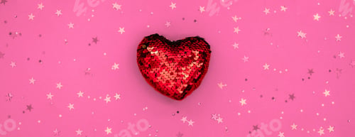 Preview: Christmas or Valentines composition made from glowing red heart decoration and glitter on pink