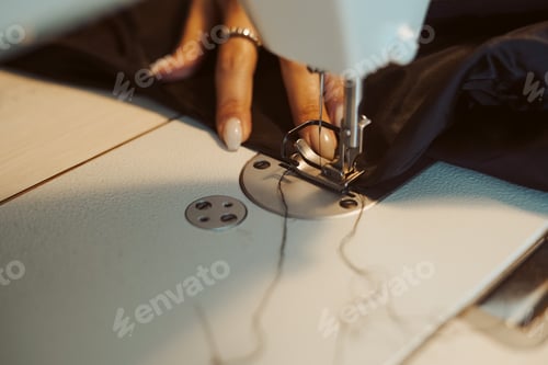Preview: Woman tailor hands working on sewing machine.