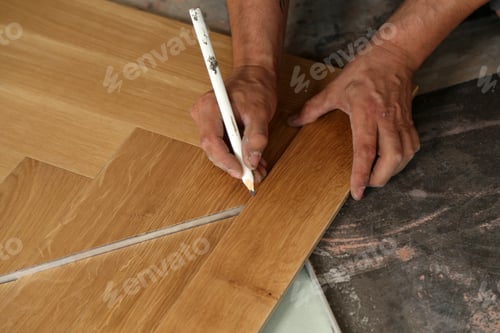 Preview: Closeup shot of a worker installing wooden flooring