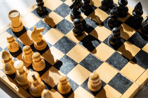 Preview: Top view of chess on wooden chessboard with shadow on wooden surface