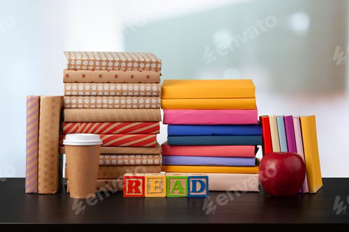 Preview: Stack of books on wooden table against blurred background