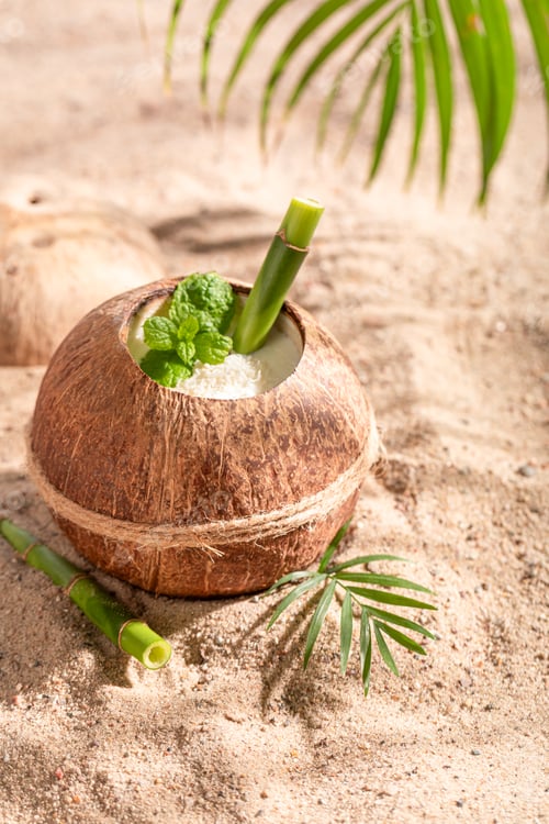 Preview: Delicious pinacolada in coconut on sandy island beach.