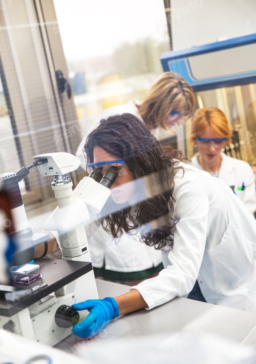 Preview: Photo of real female scientists looking into a microscope at laboratory.