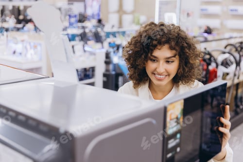 Preview: Woman Choosing Microwave Oven in Electronics Store