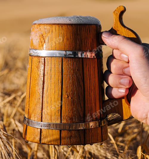 Preview: hand holding a wooden mug with beer