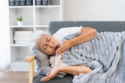Preview: Senior woman suffering from severe cough on couch