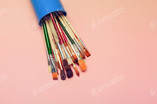 Preview: Set of art paint brushes over pastel pink background. Painting supplies, art concept