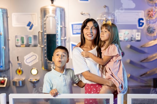 Preview: Portrait of a happy mom with her young kids in science museum