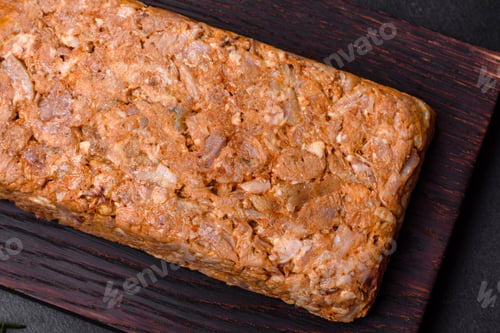 Preview: Tasty meat brawn or roll on a wooden cutting board with spices and herbs
