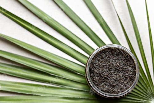 Preview: Body scrub made from natural ingredients in a jar on a palm leaf background.Handmade cosmetics.