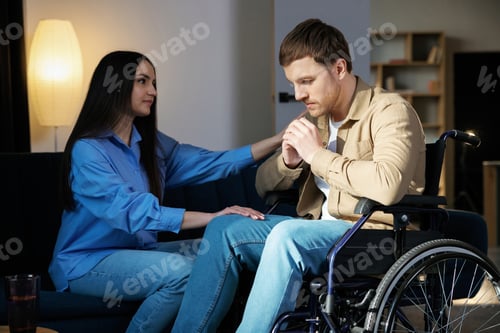 Preview: Young man in a wheelchair. Girlfriend comforting her sad boyfriend