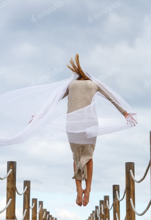 Preview: Woman with textile posing in air on footbridge