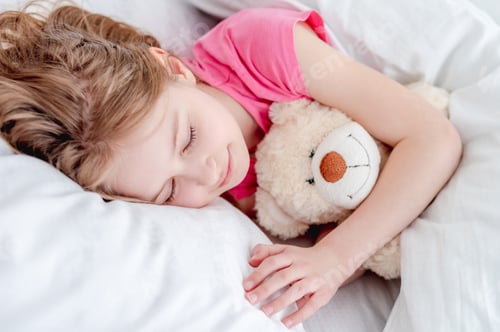 Preview: Girl Napping Peacefully with Teddy Bear in Bed