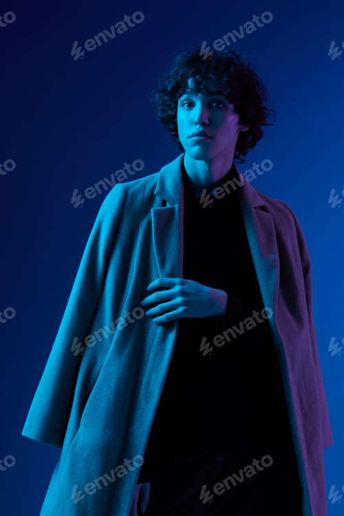 Preview: Man fashion in coat on dark blue background, neon light, style and trends, mixed light, men's