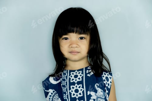 Preview: The portrait of a little child girl stands smiling looking into the camera's