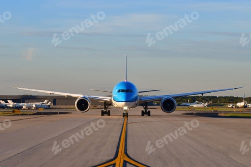Preview: A jumbo jet airplane taxing on the runway preparing to take off with the airport in the background