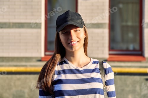 Preview: Outdoor portrait of teenage girl in black cap, city street background
