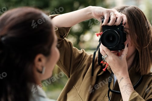Preview: Female photographer taking photo of businesswoman outdoors