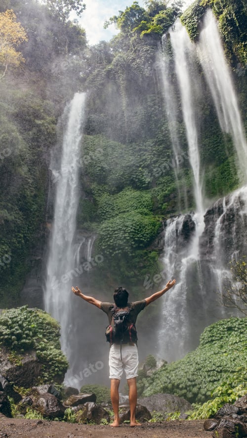 Preview: Male tourist enjoying near waterfall