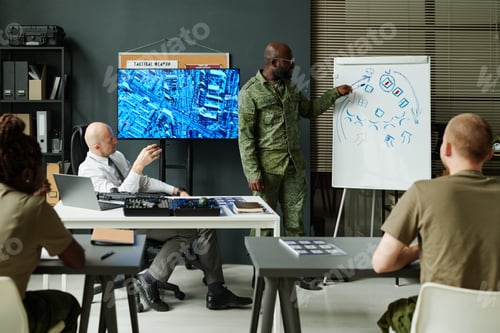 Preview: Young African American soldier in camouflage uniform pointing at whiteboard
