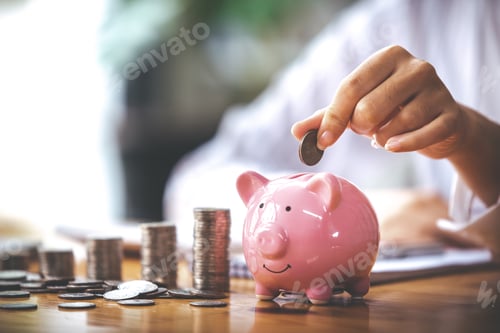 Preview: businessman holding a coin in a piggy bank On a table with sunlight. Money Saving Ideas for Financia