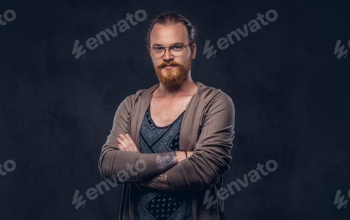 Preview: Portrait of a redhead hipster male in a studio. Isolated on the dark background.