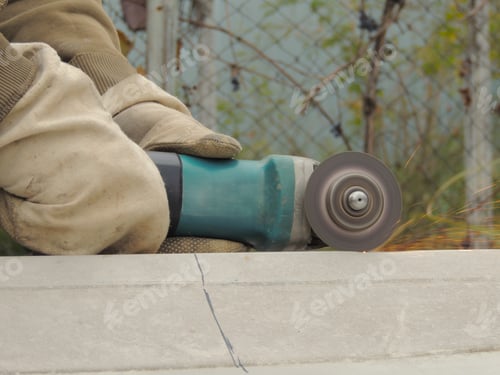Preview: A worker cuts a sheet of metal with a grinder