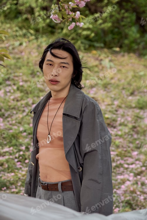 Preview: Young man showcases modern fashion in a tranquil park setting