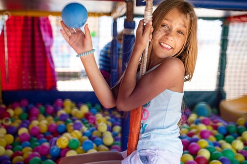 Preview: Girl in a T-shirt spends time in the playroom enjoying a summer day